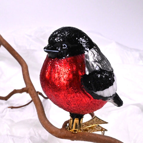 Juletrefigur I glass formet som liten fugl; dompap. Rød mage, svarte, sølvfarget og hvite vinger.
