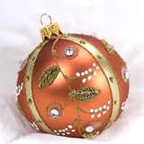 Rund kobberfarger julekule I glass. Dekorert med gull og blanke glasssteiner.