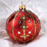 Rund julekule I glass. Malt i rødt, dekorert med gull, hvite perler og blanke glassteiner. Juletrepynt, påskepynt