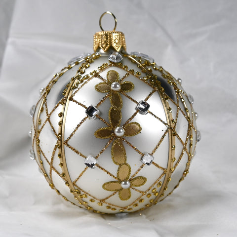 Rund julekule I glass. Malt i sølvfarge og dekorert med gulldetaljer, hvite perler og blanke glassteiner. Juletrepynt