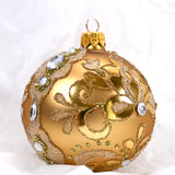 Rund gullfarget julekule I glass. Dekorert med blanke glassteiner og glitter. Juletrepynt